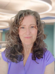 A smiling woman with curly hair.