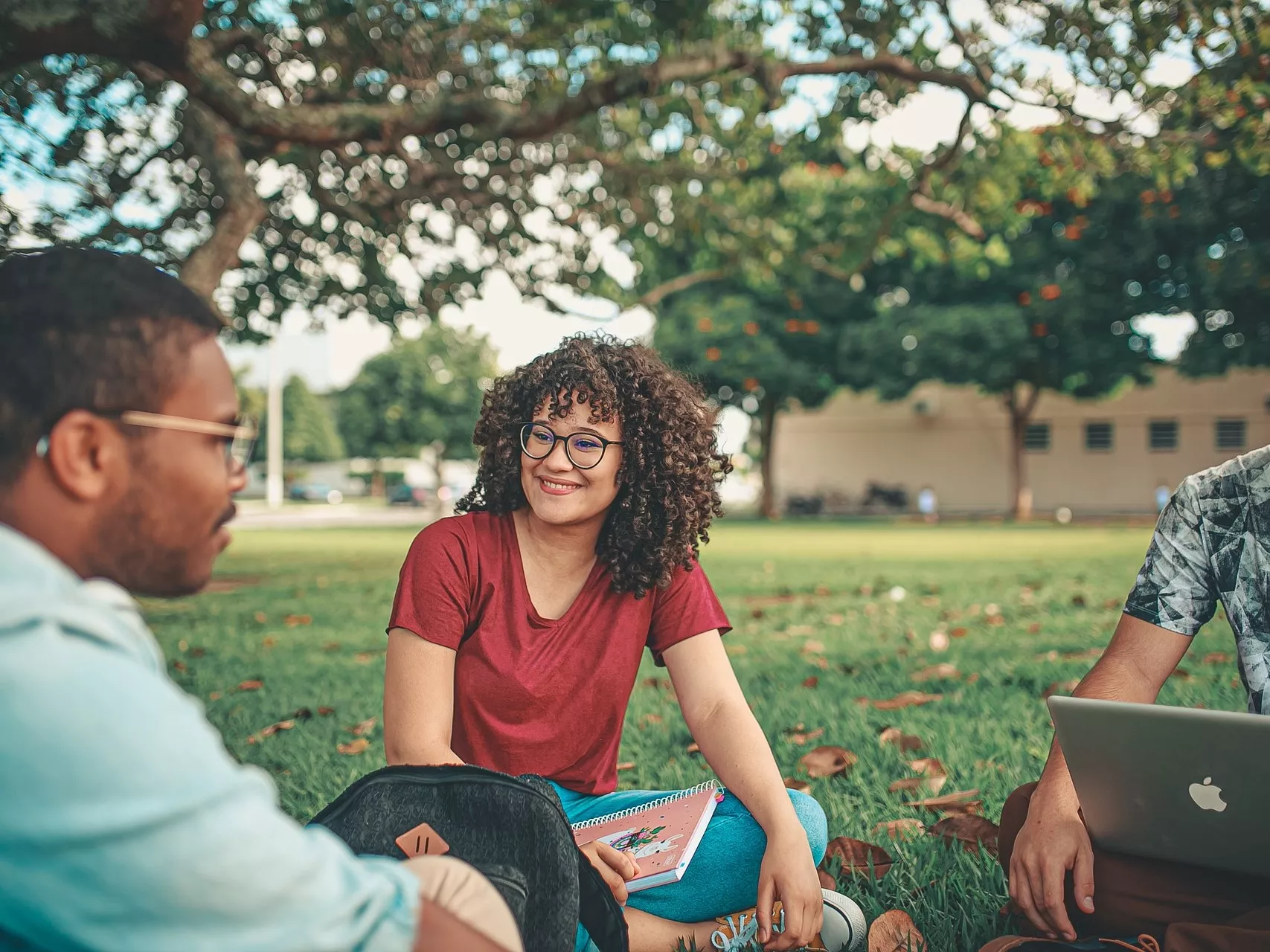 A group of people sitting outside with school supplies